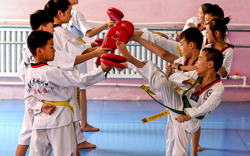 7月24日,河北省武强县一家艺术学校拳馆的孩子们在进行跆拳道腿法训练