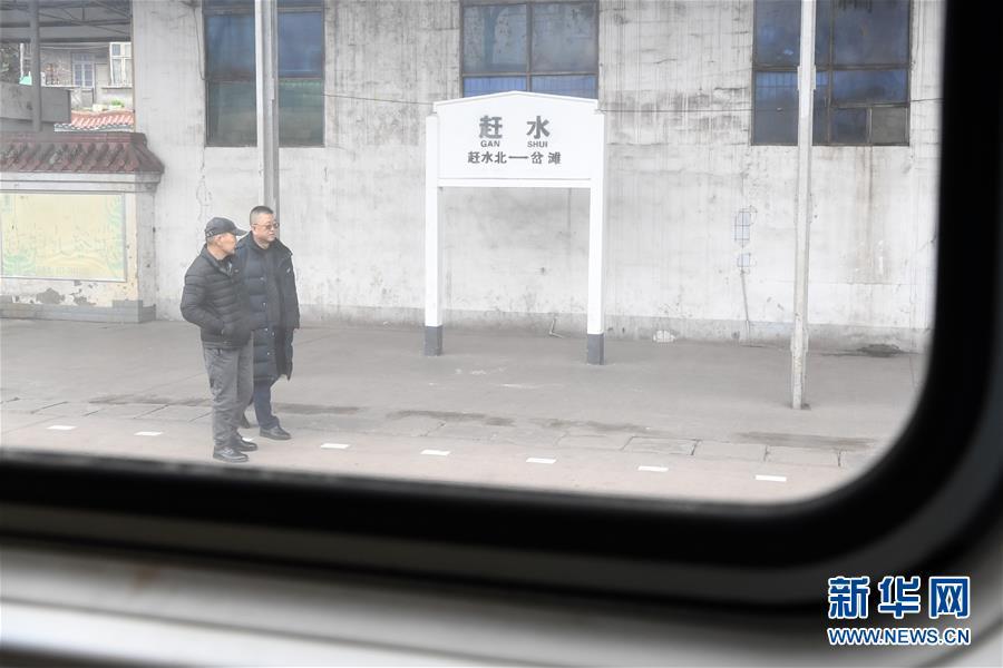 1月13日,张维华(右)在赶水火车站与乡邻攀谈.新华社记者 唐奕 摄