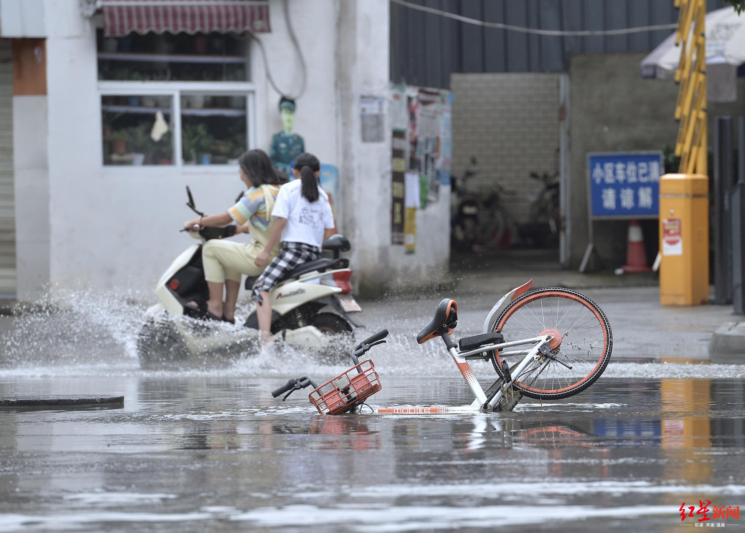 大雨后路面积水共享单车栽进路面窨井