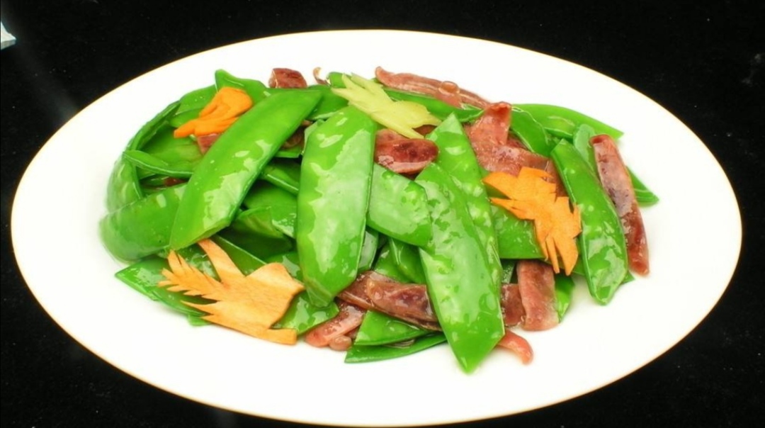 《荷兰豆炒腊肠》2.热锅冷油后,放入蒜姜片和肉片煸炒制香.