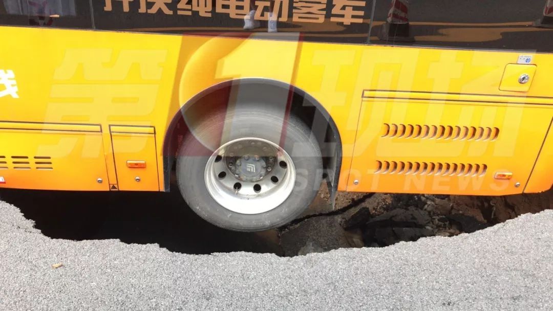 大半截公交车都陷入坑中 整台公交车微微翘起 后轮已经陷