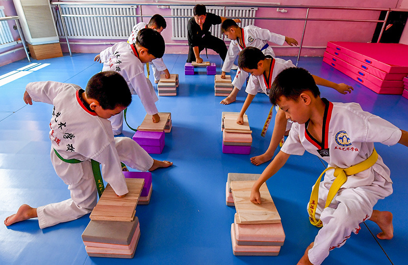 武强县一家艺术学校拳馆的跆拳道教练在指导孩子们进行跆拳道击破训练