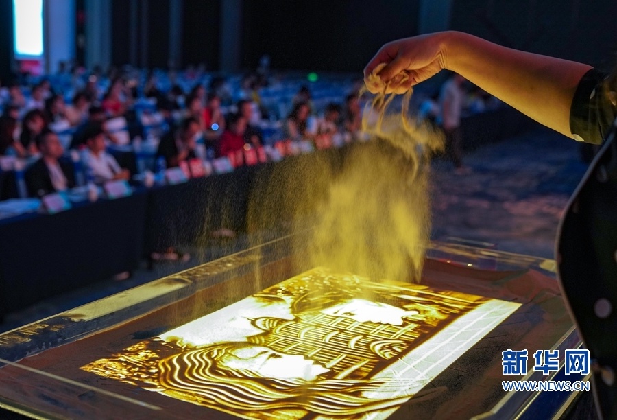 8月21日上午,一名选手在沙画表演比赛中现场创作楼宇,扬沙瞬间颇为