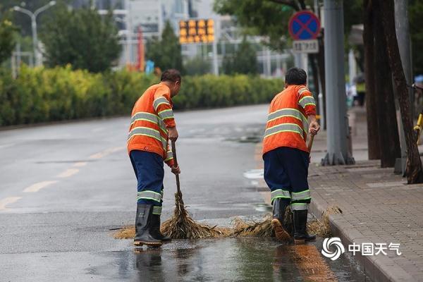 光明网：雨水添凉意 北京街头行人短袖换长衫