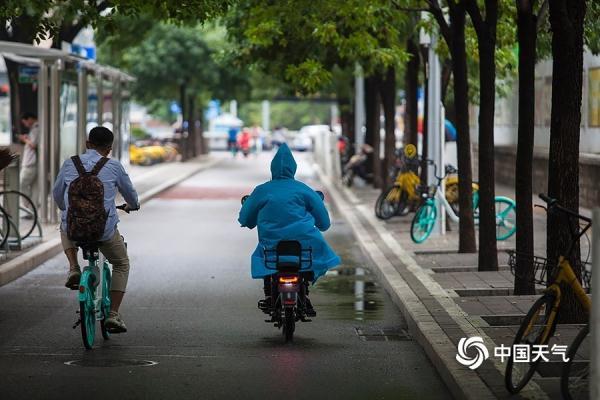 光明网：雨水添凉意 北京街头行人短袖换长衫