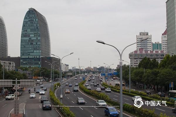 光明网：雨水添凉意 北京街头行人短袖换长衫