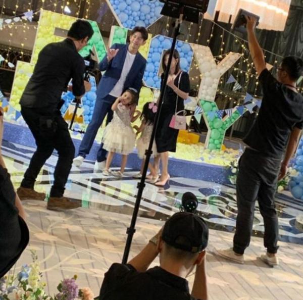 「光明网」贾静雯全家一起出席活动，咘咘见镜头不怯场，波妞害羞转头躲开