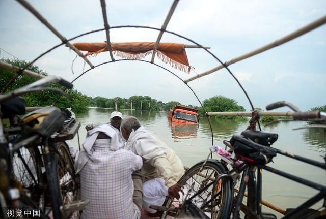 「环球网」印度阿拉哈巴德遭遇洪水 当地道路被淹居民划船出行