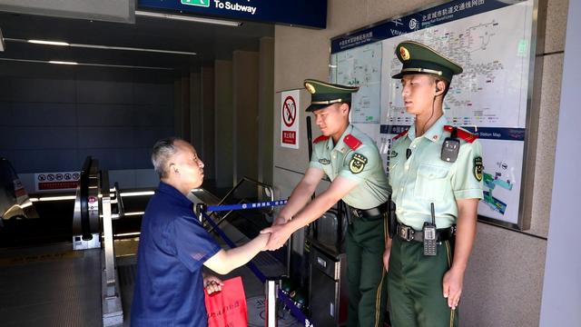 「新京报」北京一老人突发不适当街瘫倒，执勤武警协助救治送医