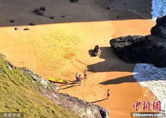 [中国新闻网]英国皮划艇运动员在沙滩上留下求救信息 被路人发现终获救
