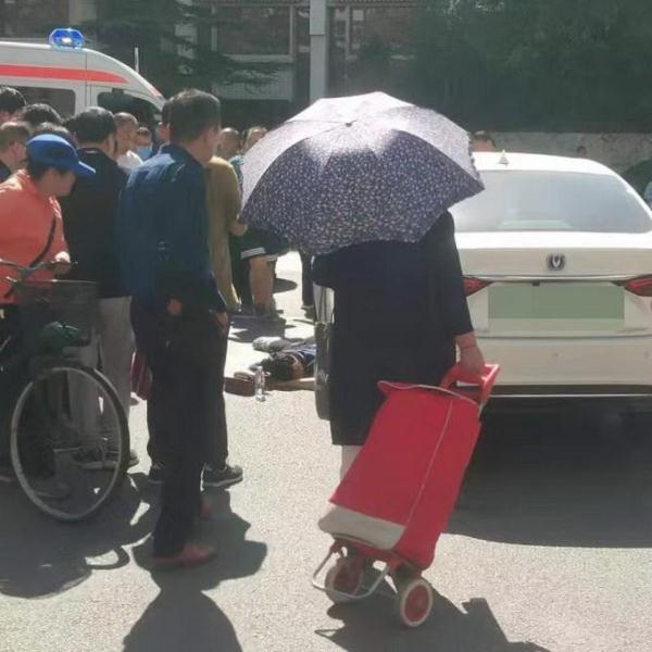 光明网@“啊”的一声惨叫，年轻女子被卷车轮下司机吓懵了，众人协力抬车救人