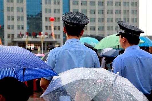 海外网■公安民警雨中执勤小男孩踮脚为其撑伞