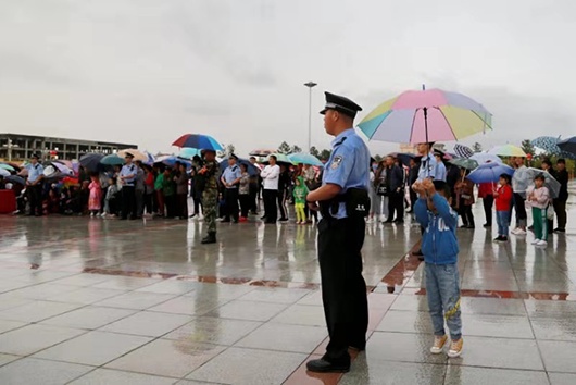 海外网■公安民警雨中执勤小男孩踮脚为其撑伞
