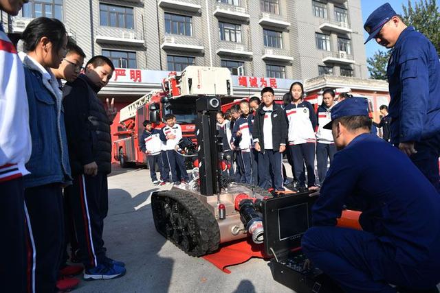 [新京报]校园消防课 女生试穿消防员服 同学惊呼“太帅了”