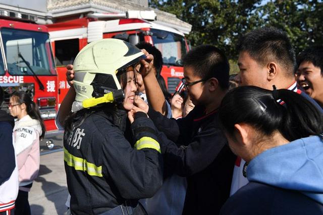 [新京报]校园消防课 女生试穿消防员服 同学惊呼“太帅了”