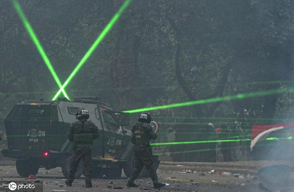 【海外网】智利首都暴力冲突不断升级 示威者脚踢警察镭射枪乱照