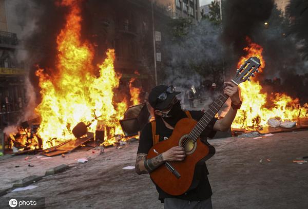 【海外网】智利首都暴力冲突不断升级 示威者脚踢警察镭射枪乱照