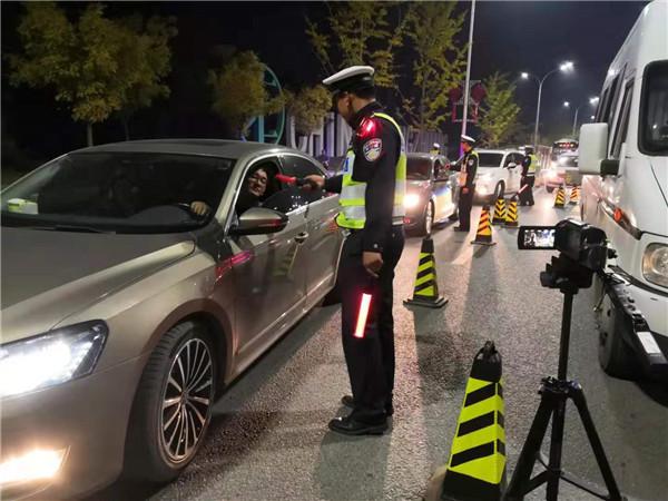 图为交警使用新式酒精检测仪排查酒驾.