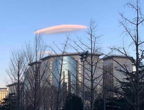 新民网@北京上空惊现粉色“飞碟云”，气象部门：属高积云，形似豆荚