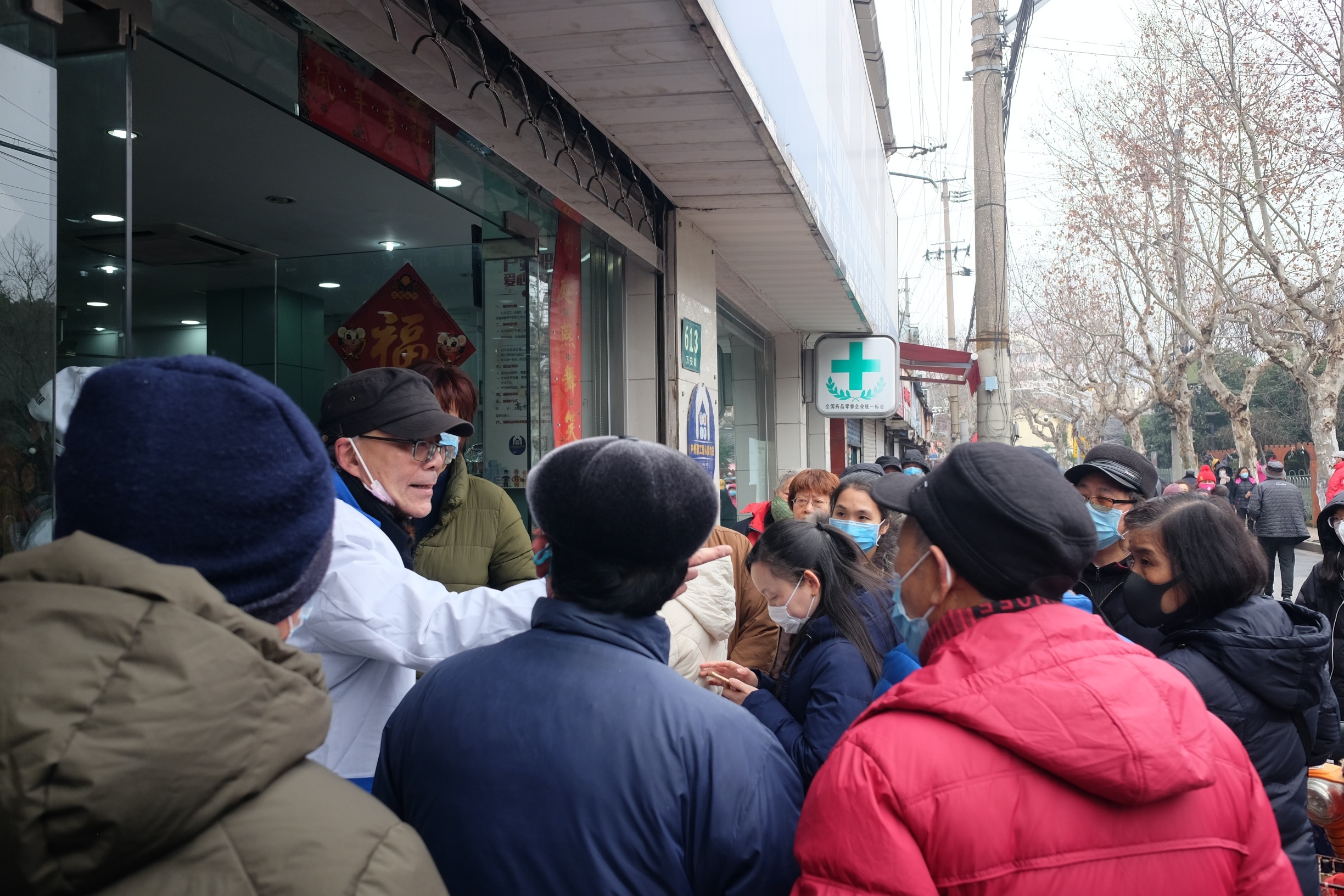 2020年1月28日,上海某药店门口,老医师劝排队购买口罩的顾客不要长