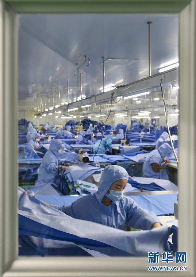 佛山康得福公司员工在医用防护服生产线缝制产品(3月3日摄).