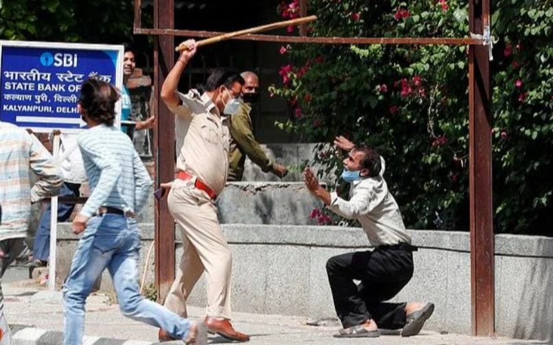 文汇报▲印度酒类商店重开引来500人“长龙”，警察不得不挥舞长棍驱赶人群