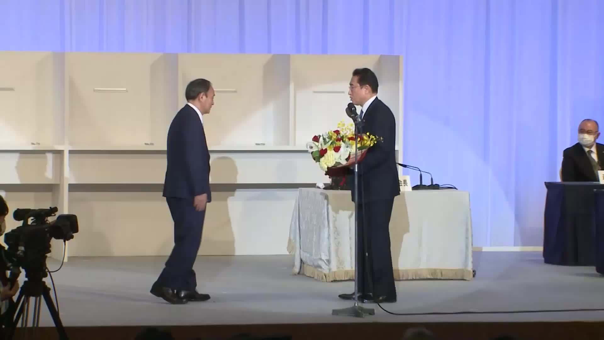 岸田文雄即将就任日本第100任首相02向菅义伟鞠躬致谢献上鲜花