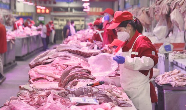 5月20日,新发地市场的肉类批发商户在摊位上工作