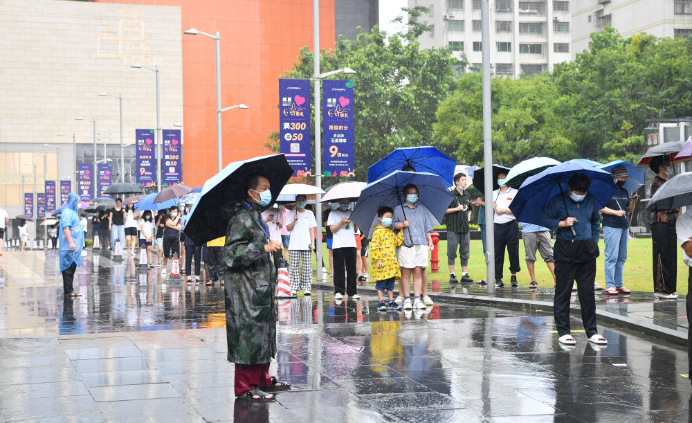 8月10日，海口市民和游客在风雨中排队做核酸。新华社记者 杨冠宇 摄