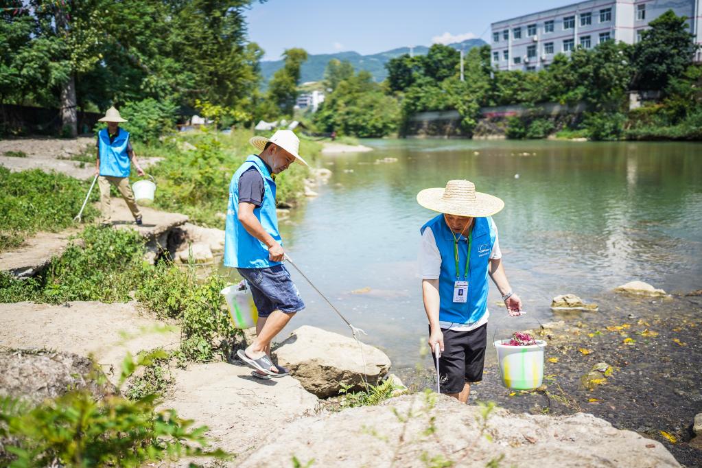 仁怀市五马镇生态环境保护协会会员在五马河岸边捡拾垃圾。新华社记者陶亮 摄