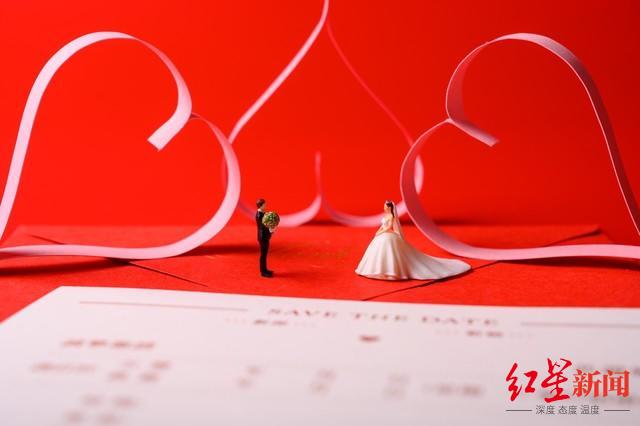 1667975512201681.jpg 红色背景上放着的婚礼请柬和微缩景观婚礼.jpg