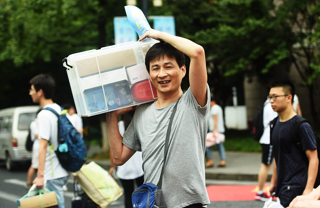 又到一年开学季 家长肩扛背挑送孩子进大学-新湖南