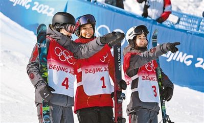 2月18日，自由式滑雪女子U型场地技巧决赛后，获得冠军的中国队选手谷爱凌（中）和获得亚军的加拿大队选手凯茜·夏普（左）、获得季军的加拿大队选手蕾切尔·卡克愉快地交流。人民日报记者 伊 霄摄