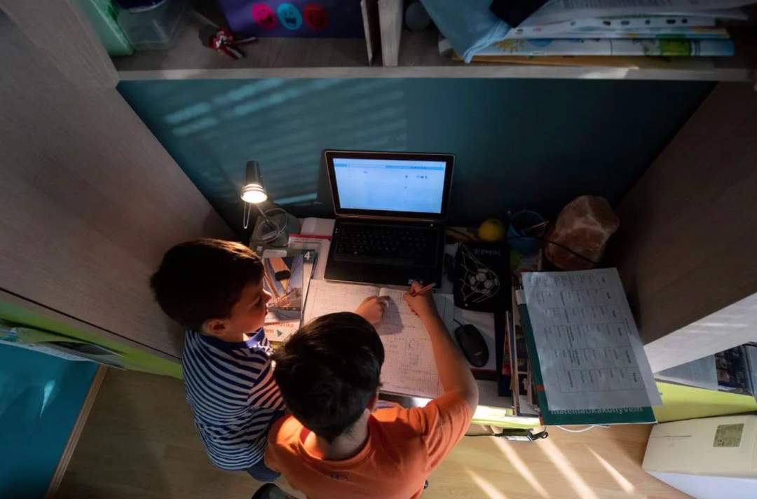 由于学校停课，学生们在家上网学习图源：美联社