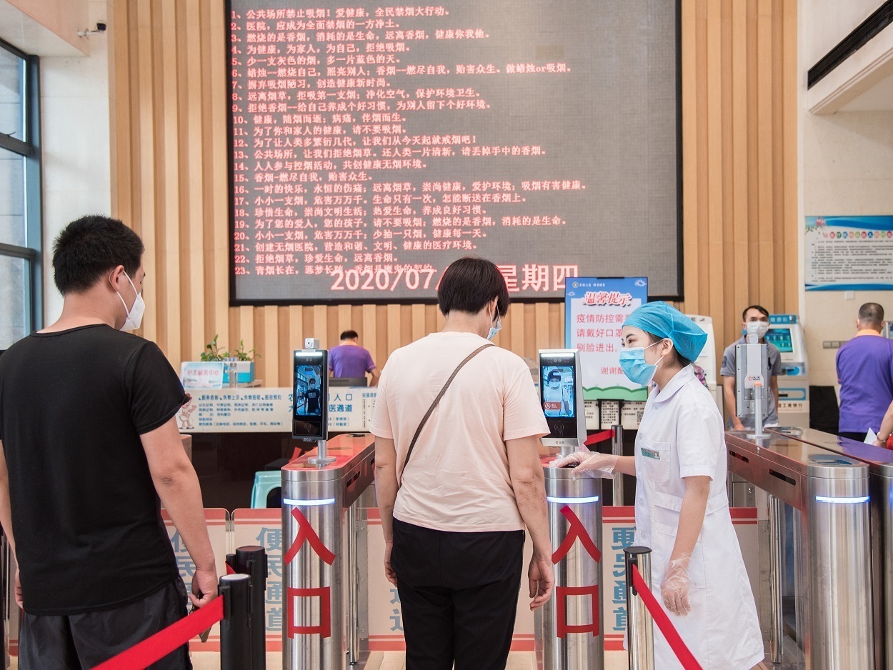 5、在住院大楼一层入口处，佩戴口罩的群众正在刷脸认证，有序通过闸口    周锦缎摄.jpg