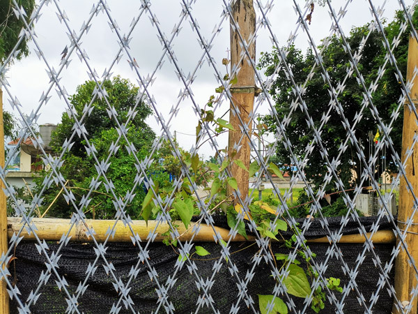 6贺哈已建成的防护网，透过网格缝隙，对面可见的建筑为缅甸一方的村庄房屋。（人民网 符皓 摄）.jpg