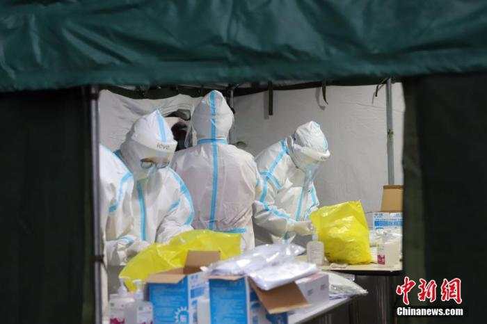 11月21日，受新冠肺炎疫情影响，天津市滨海新区对辖区内全体居民进行大规模核酸检测筛查。图为核酸检测取样现场忙碌的医务工作者。 中新社记者 张道正 摄