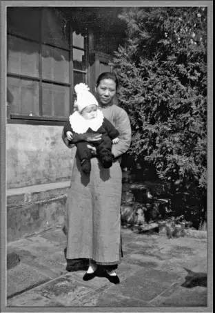1938年,不到一岁的李忆祖被养母抱着在北京家中四合院留影.