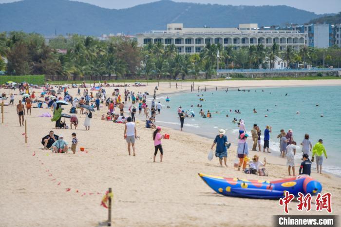 图为三亚大东海旅游景区的沙滩吸引了许多游客前来游玩，享受阳光沙滩。　骆云飞 摄