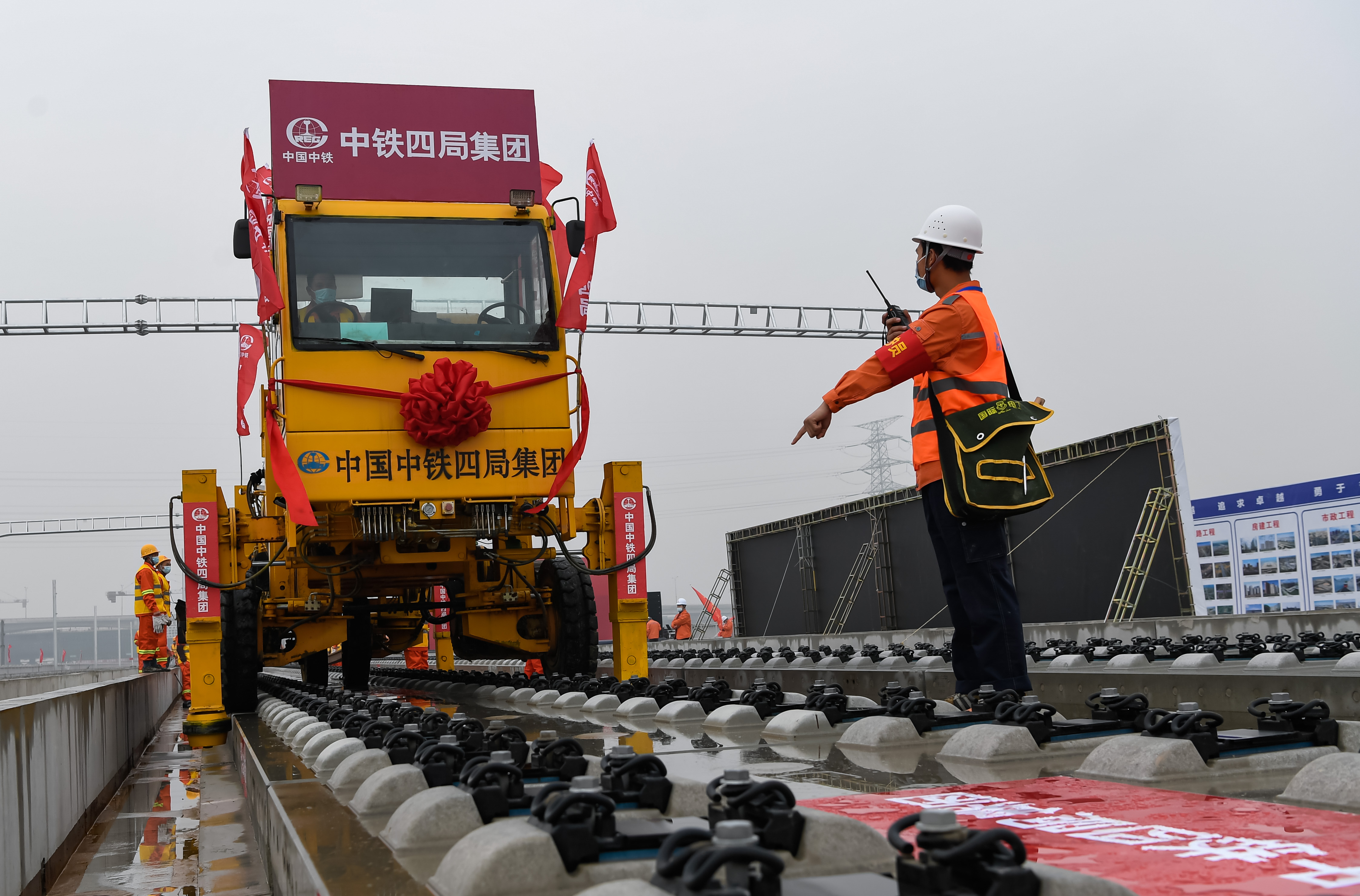 1639734704653653.jpg 现场防护员盯控长钢轨牵引车作业 吴怀球摄.JPG