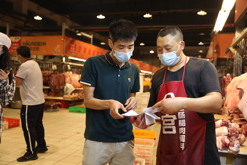 尹涵与肉摊老板核对供求信息。章磊摄_副本.jpg?x-oss-process=style/w10