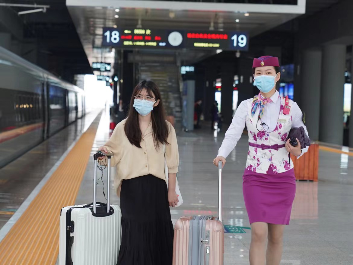 1683003328387060.jpg 图10 节日期间,列车长在站台帮助旅客提拿行李.jpg