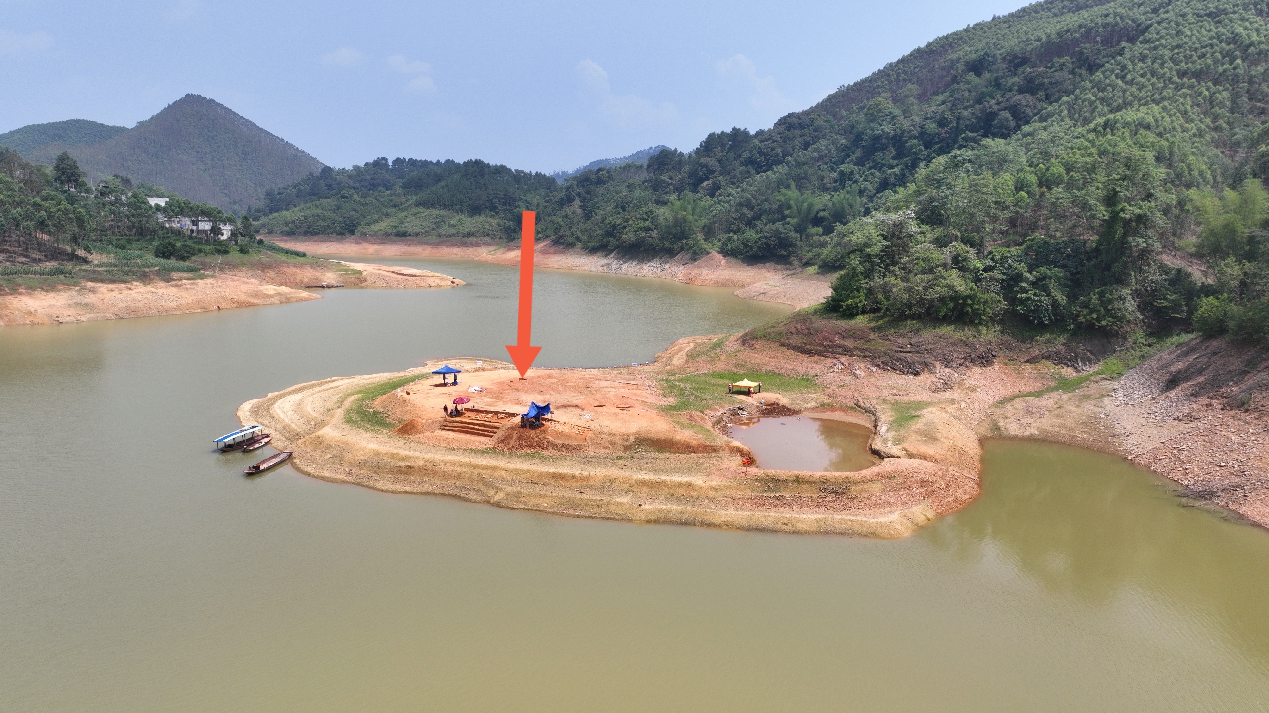 发现战国古墓的达洪江水库库区半岛（箭头处为铜鼓发掘位置）。□本报记者 覃蔚峰 摄.jpg