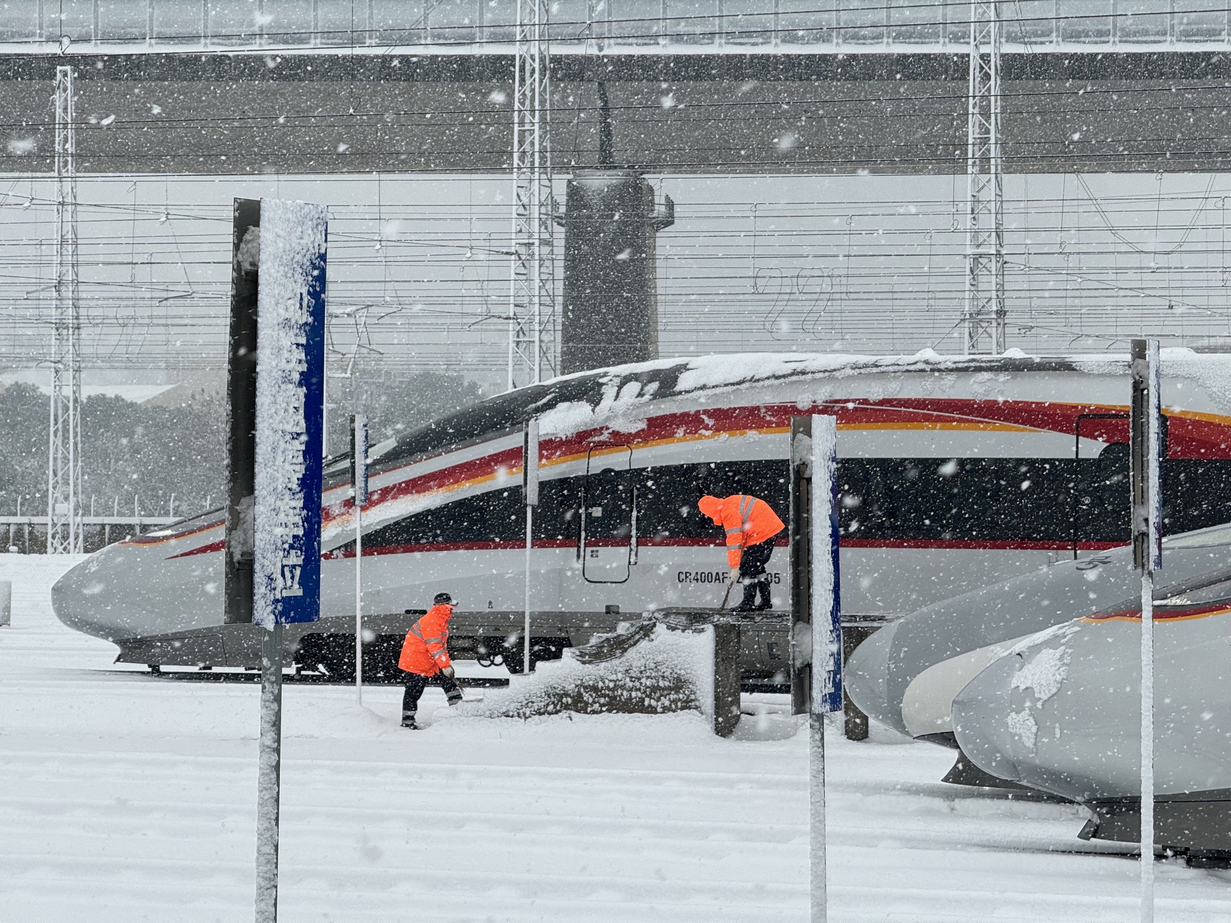 1705930747787636.jpg 南昌车辆段工作人员在南昌西动车组运用二所对存车线进行扫雪除冰。肖尧 摄.jpg