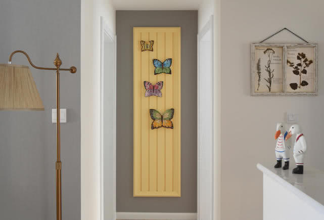 卧室门口的墙壁上还设计了一幅装饰画,远远看上去像是几只蝴蝶在翩翩