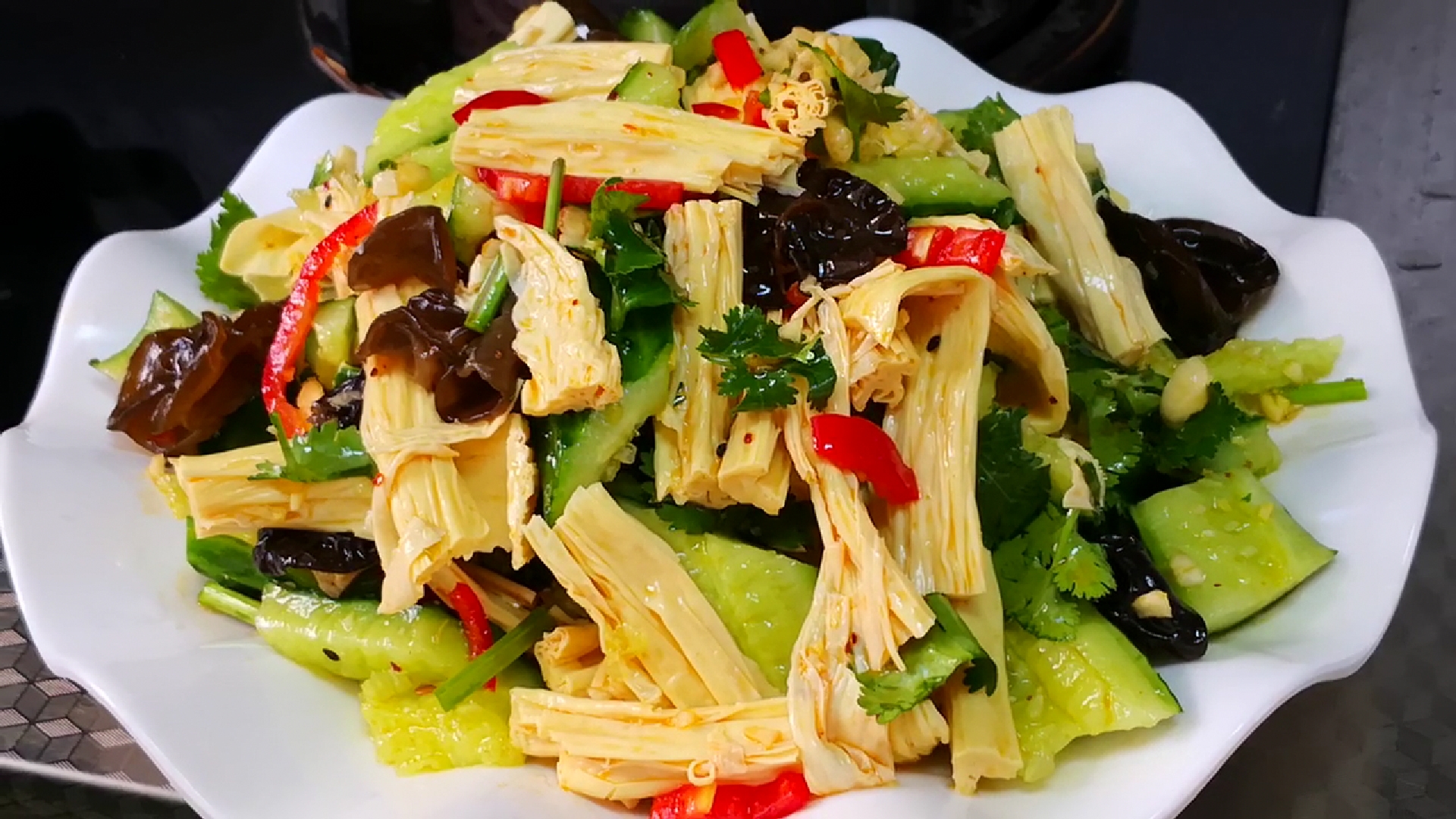 先将洗净的黄瓜去头去尾,然后拍碎,再切成块;再将泡发好的腐竹切成段