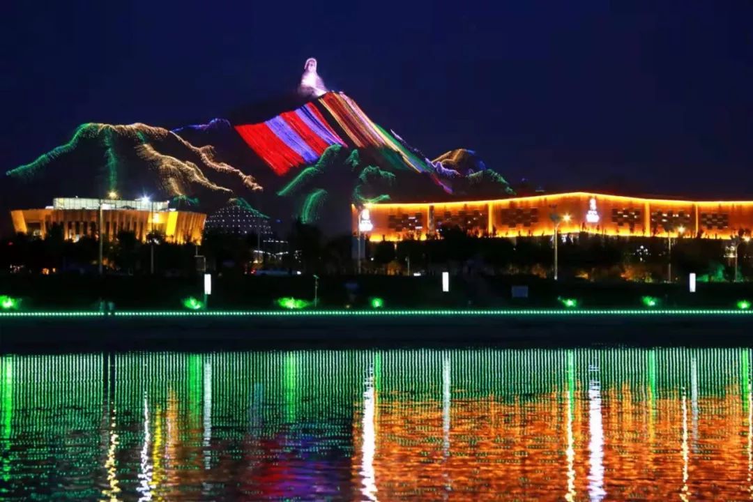 这里天黑的晚,八九点街上正是热闹的时候,乌海湖对面的甘德尔山上立着