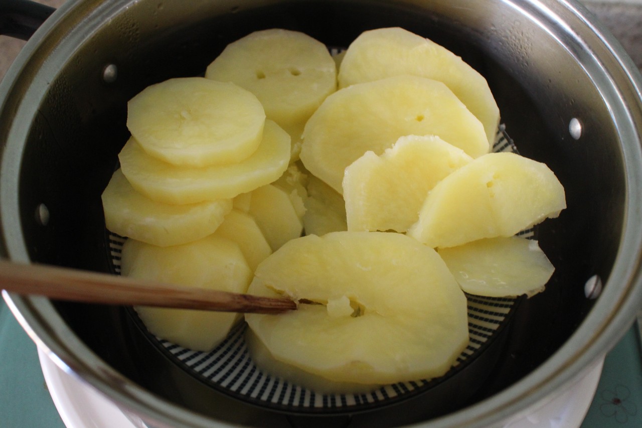 将土豆片放入锅中蒸15分钟左右,拿一根筷子戳一下土豆片,能扎进去