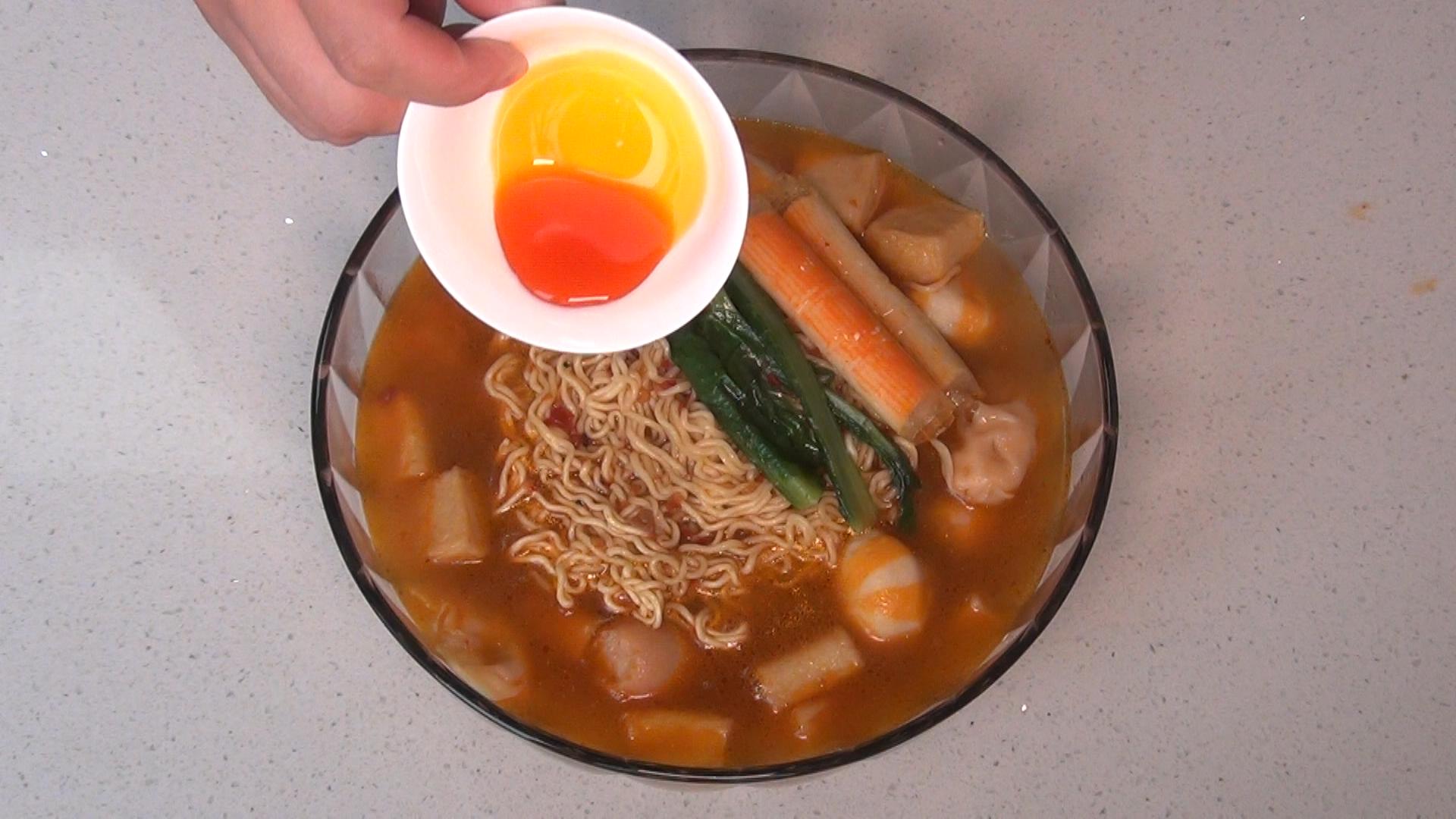 8.方便面煮2分钟后,把方便面和火锅丸一起放入碗中,再倒入适量的汤汁.