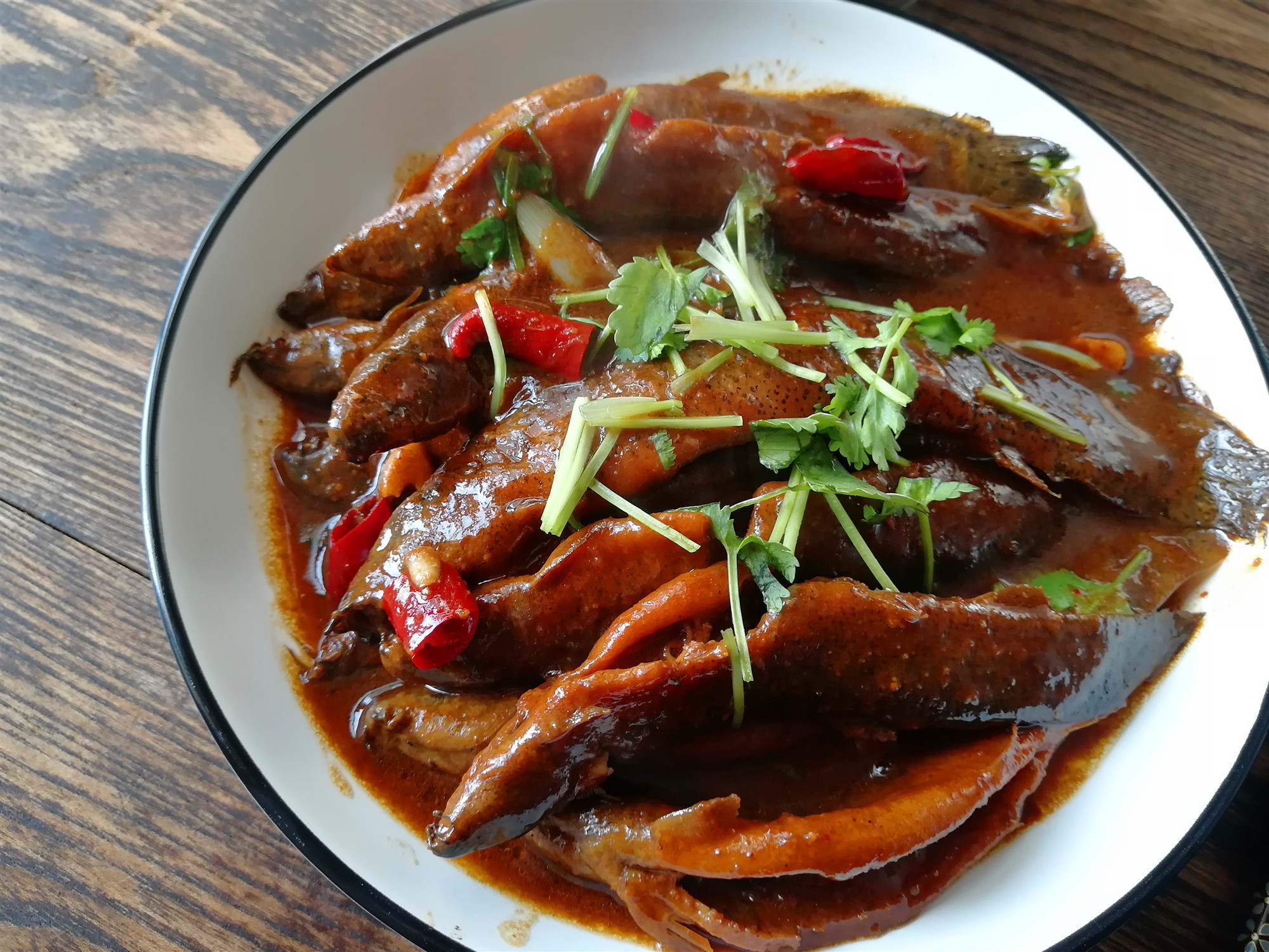【酱焖泥鳅鱼】材料:泥鳅鱼500克,香菜1棵,油适量,黄豆酱100克,葱1段